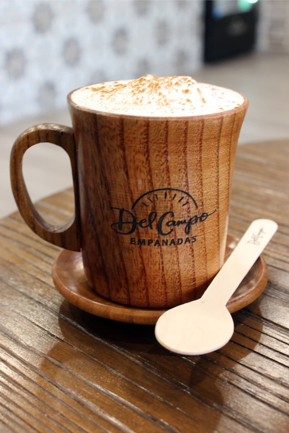 A cup of coffee featuring foam and cinnamon on top.