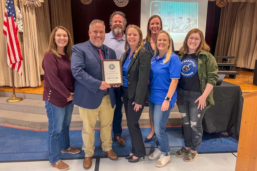 New Braunfels ISD administrators and staff present the plaque commemorating the 100th anniversary of Mirabeau B. Lamar Elementary School. (Sierra Martin/Community Impact)