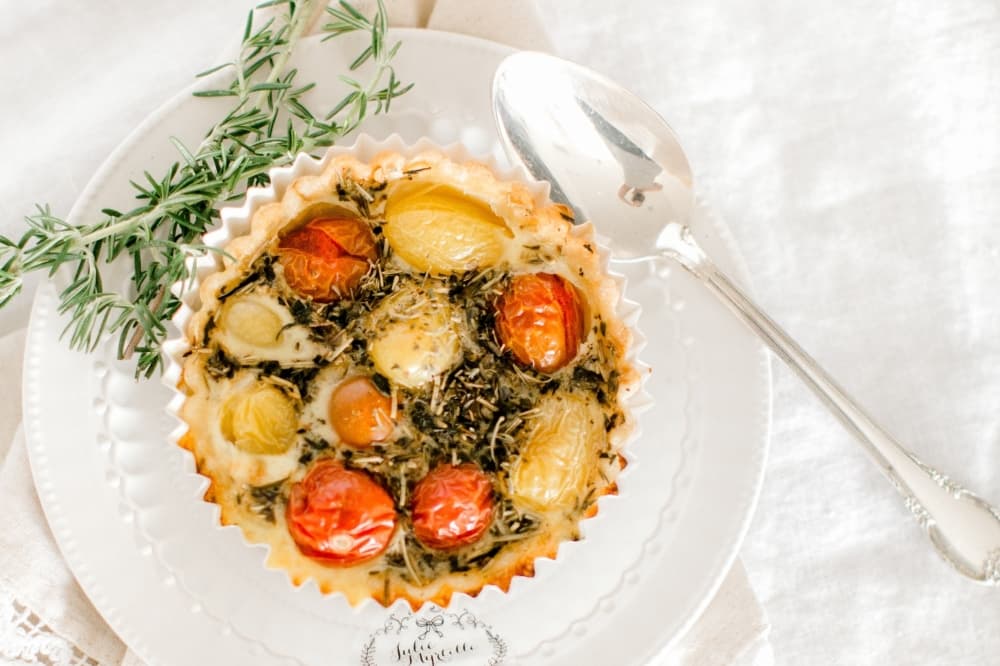 A white plate displays a tomato-based quiche.