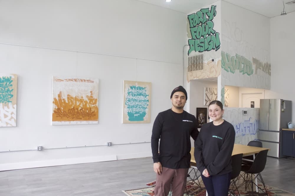 two people stand in an art gallery
