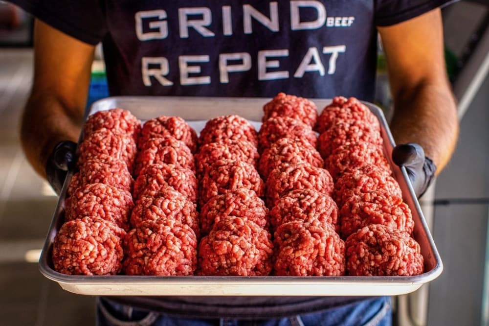 rows of raw beef rolled into balls on a tray