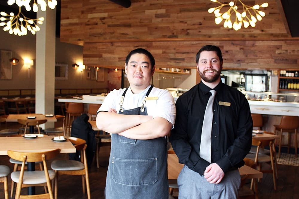 Two men standing in a restaurant.