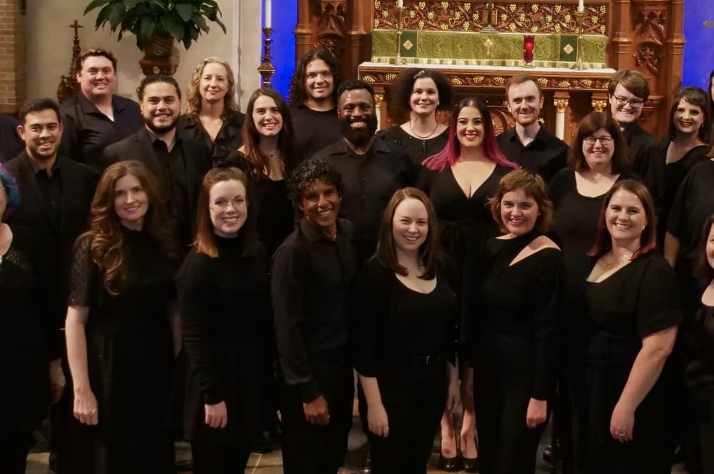 Dressed in black, the choir poses for a photo.