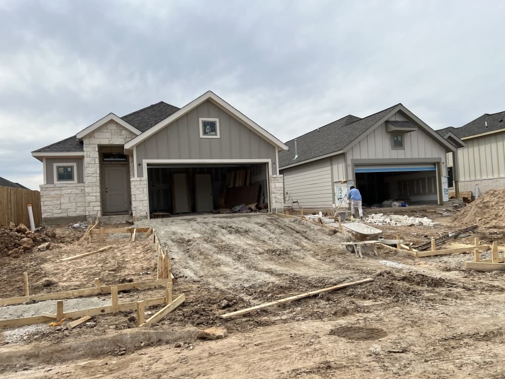 Two homes under construction, dirt lots 