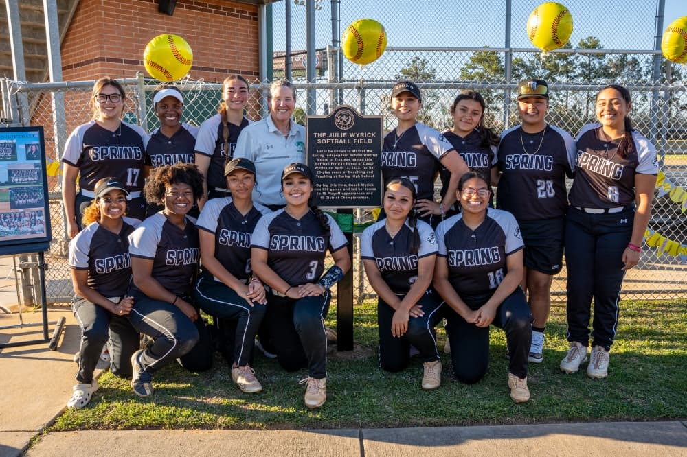 The photo shows a softball team and coach Julie Wyrick. 