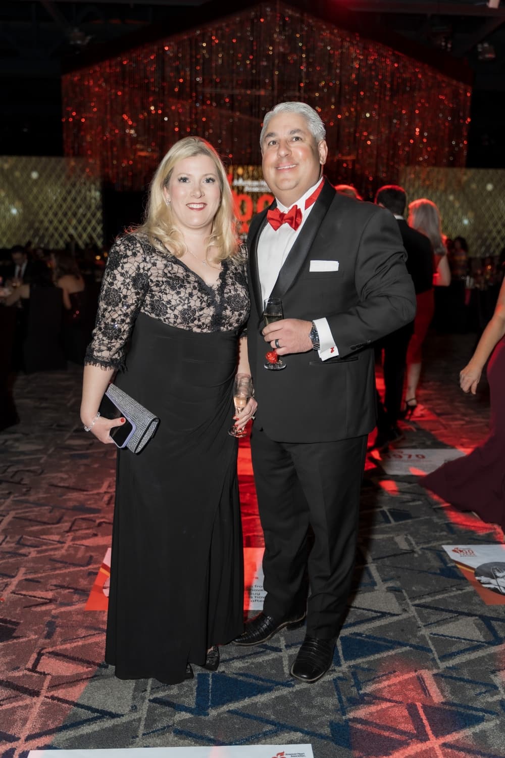 Two people in black formalwear pose 