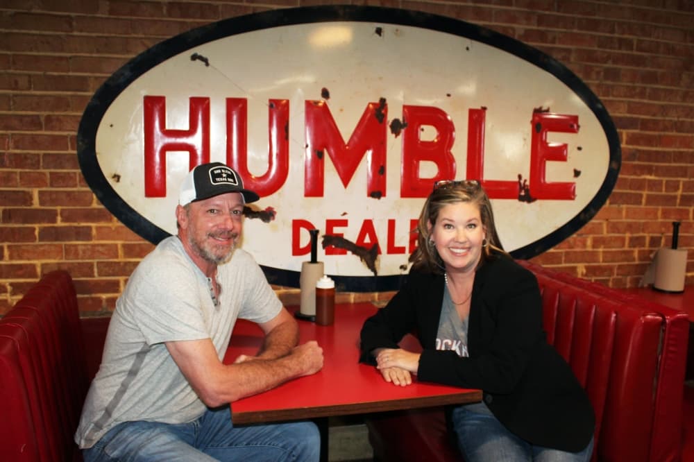 Man and woman sitting across from each other in a booth at a restaurant.