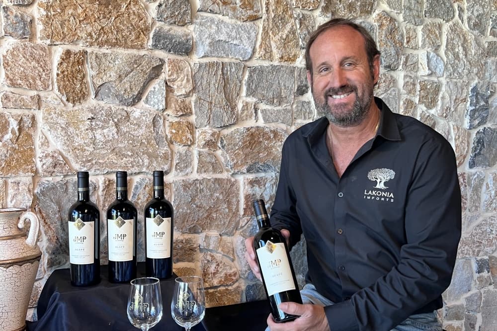 Owner holding wine bottle