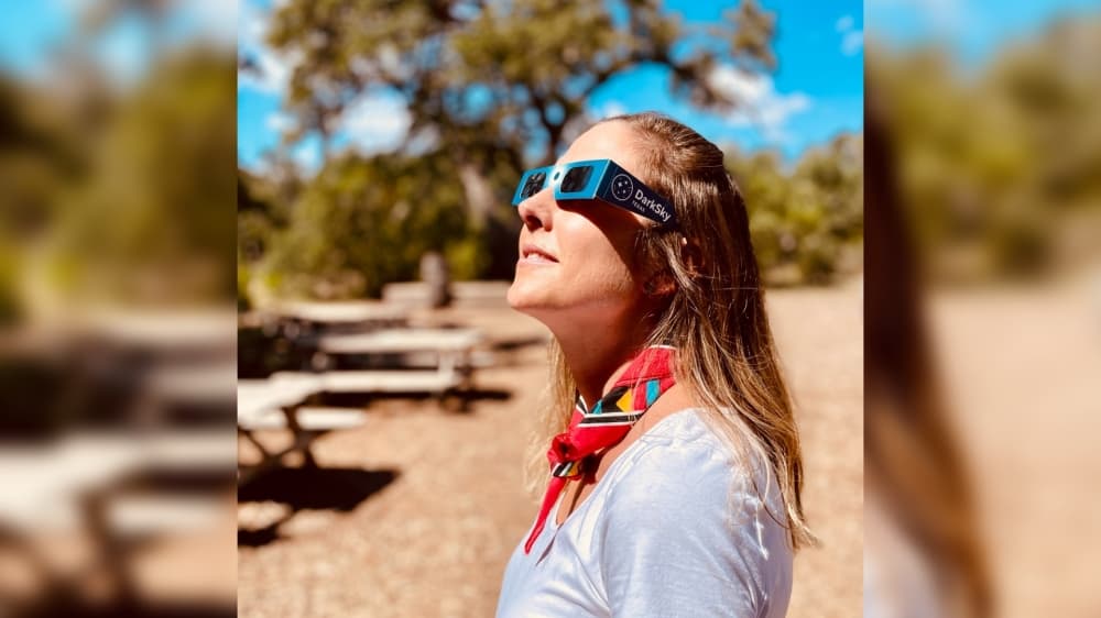 a girl wearing eclipse glasses