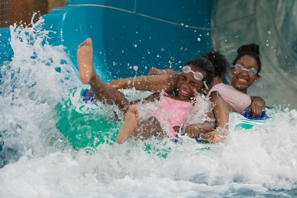Photo of two children on a tube, sliding down a water slide. (Courtesy Great Wolf Lodge)