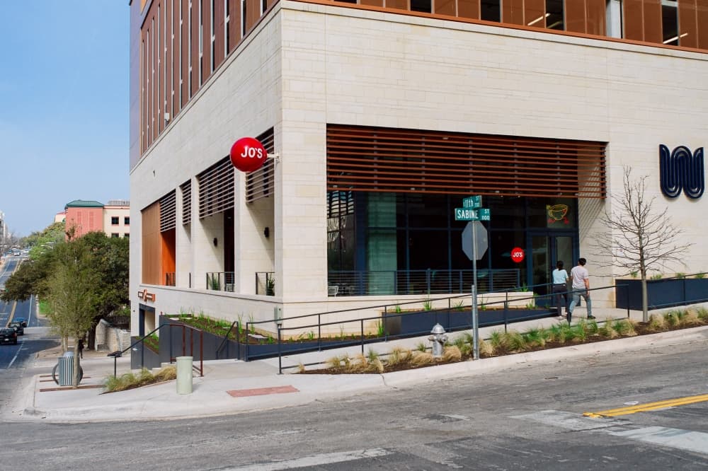 The exterior of the building is shown at the corner of Sabine and 11th Street. 