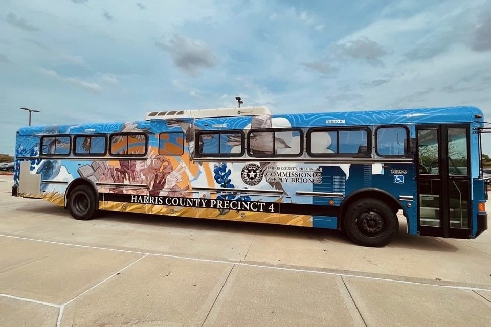 A photo of a Precinct 4 school bus covered in student art.