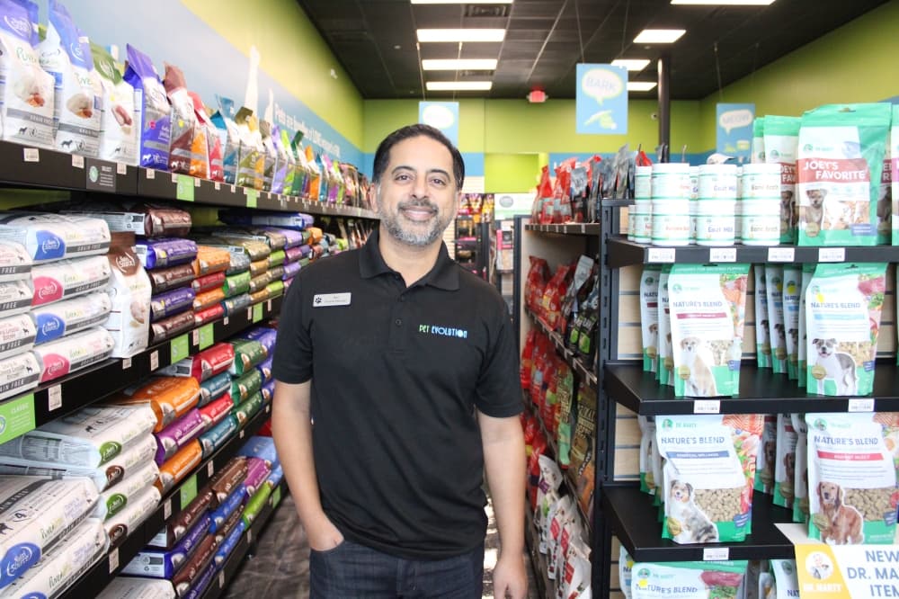 Neil Sheth standing in an aisle at Pet Evolution. 