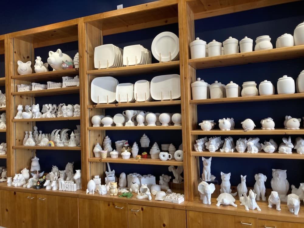 A shelf with ceramic figures, several of them painted