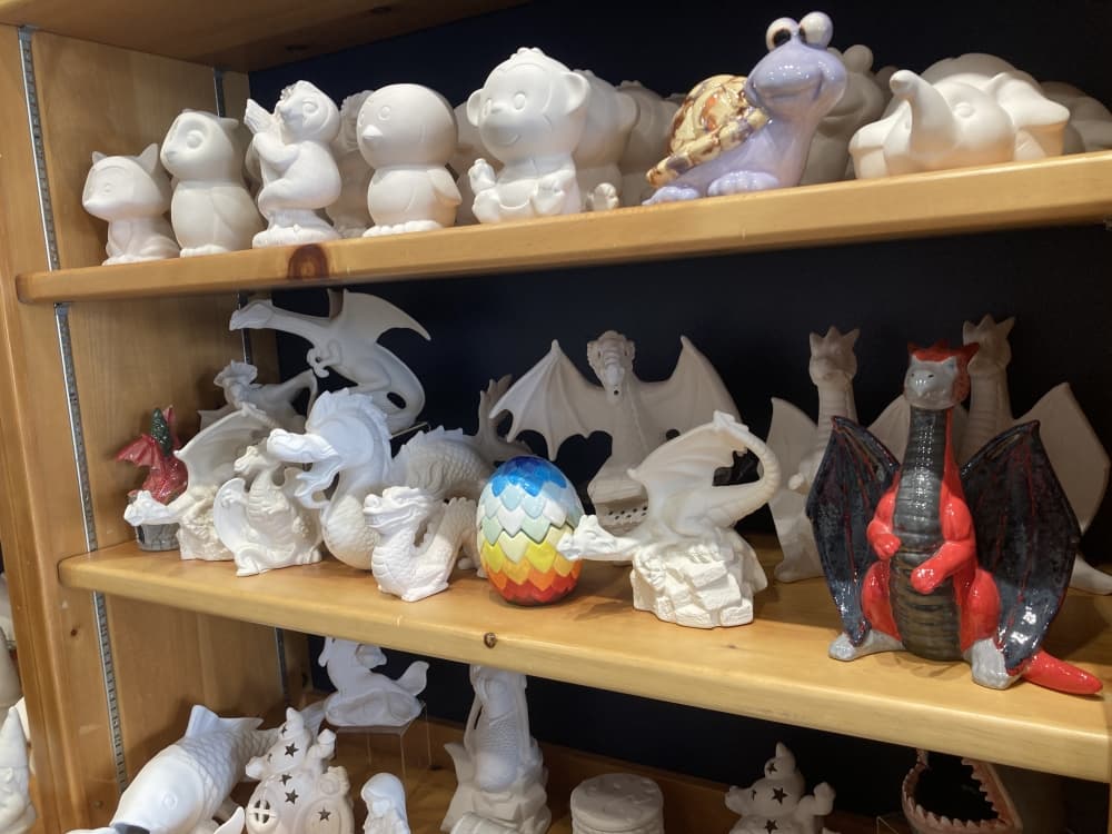 A shelf with ceramic figures, several of them painted