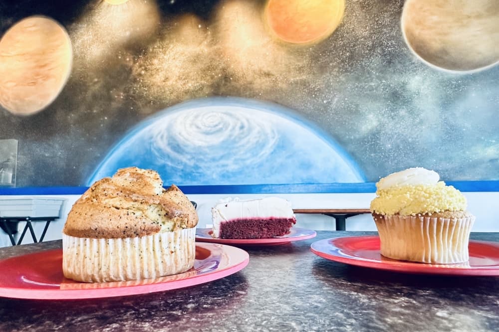 Two pastries and a dessert a shown with the Rocket Coffee ATX space-themed wall in the background.