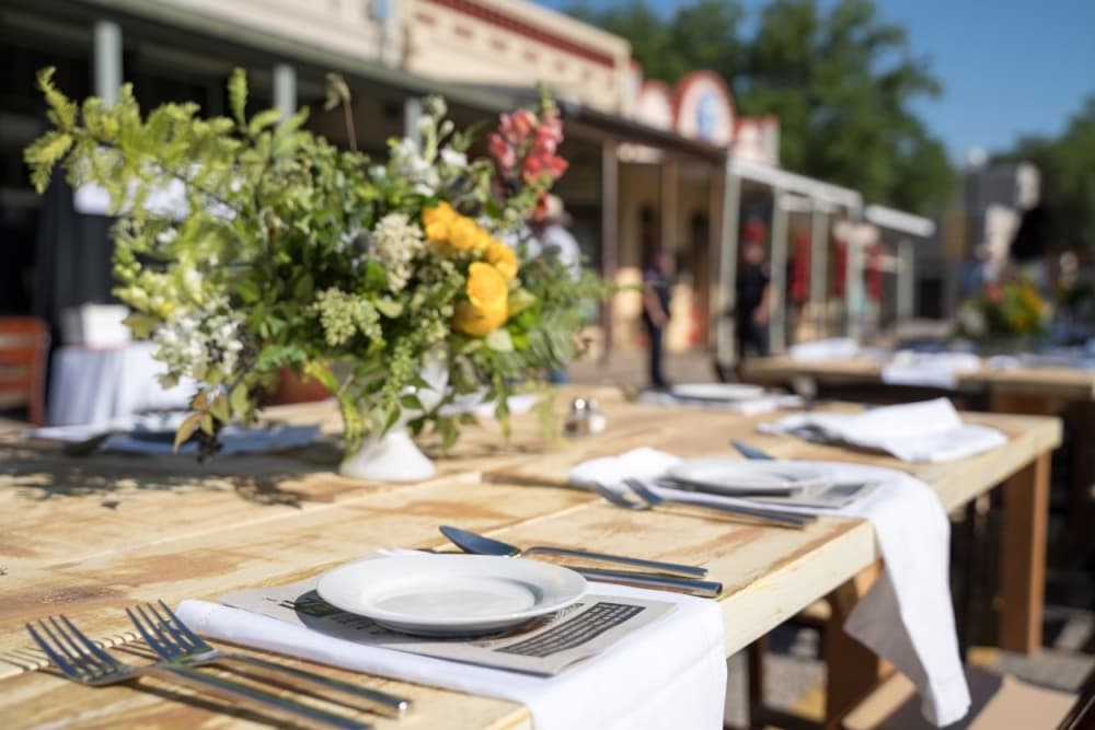 A table is shown on Main Street decorated with flowers and dinnerware.