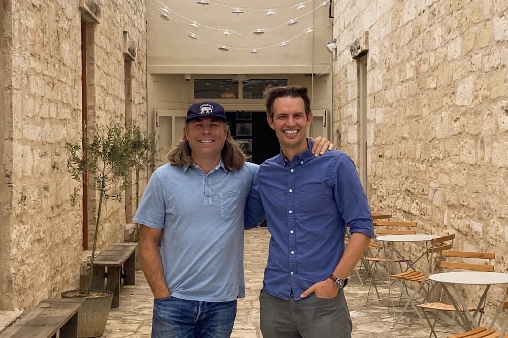 The two owners pose for a photo.