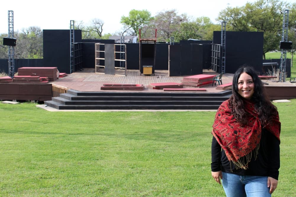 Woman standing in front of an outdoor stage.