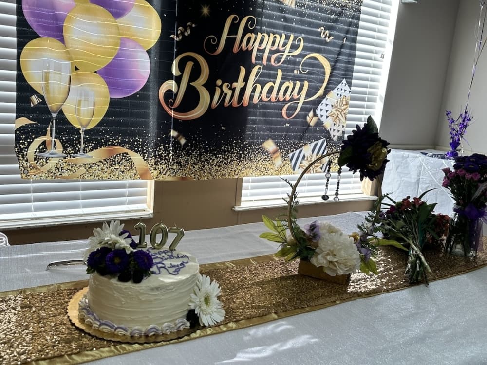 The table is set with a cake and flowers.