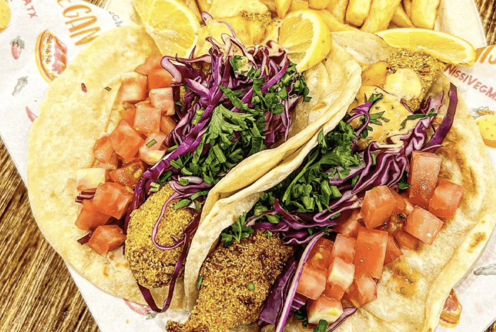 Two tacos are shown with breaded banana blossoms that look like fish strips.