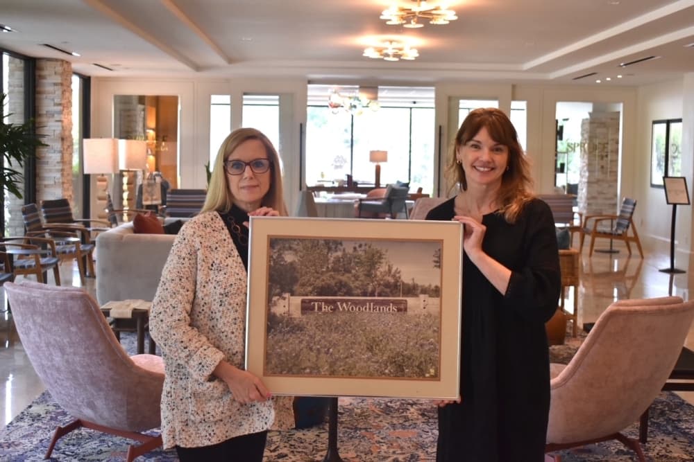Two women hold a framed picture