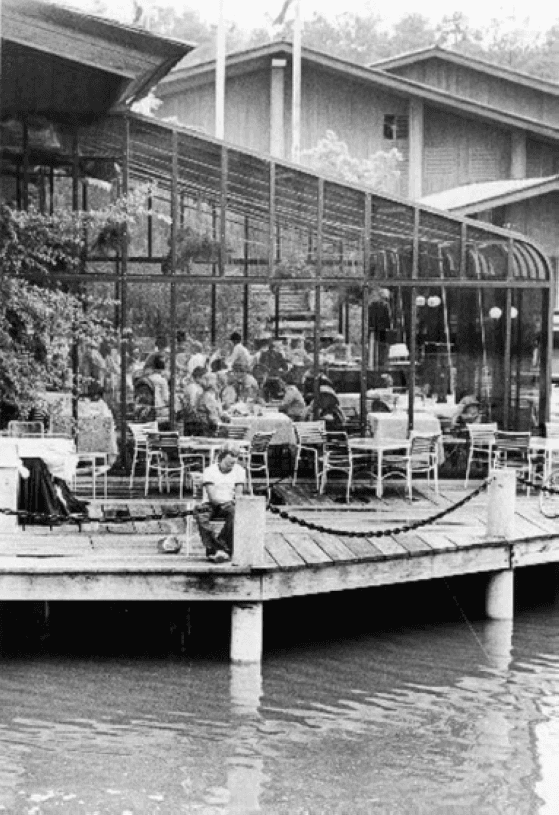A black and white photo of a wharf with a restaurant