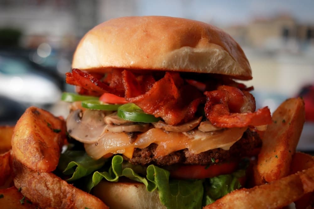 "The Works" burger at The Taproom is a half-pound medium well patty with Swiss and American cheese, grilled mushrooms, onions and jalapeños, bacon, lettuce, tomato and pickles on a toasted sweet sourdough bun. (Courtesy The Taproom)