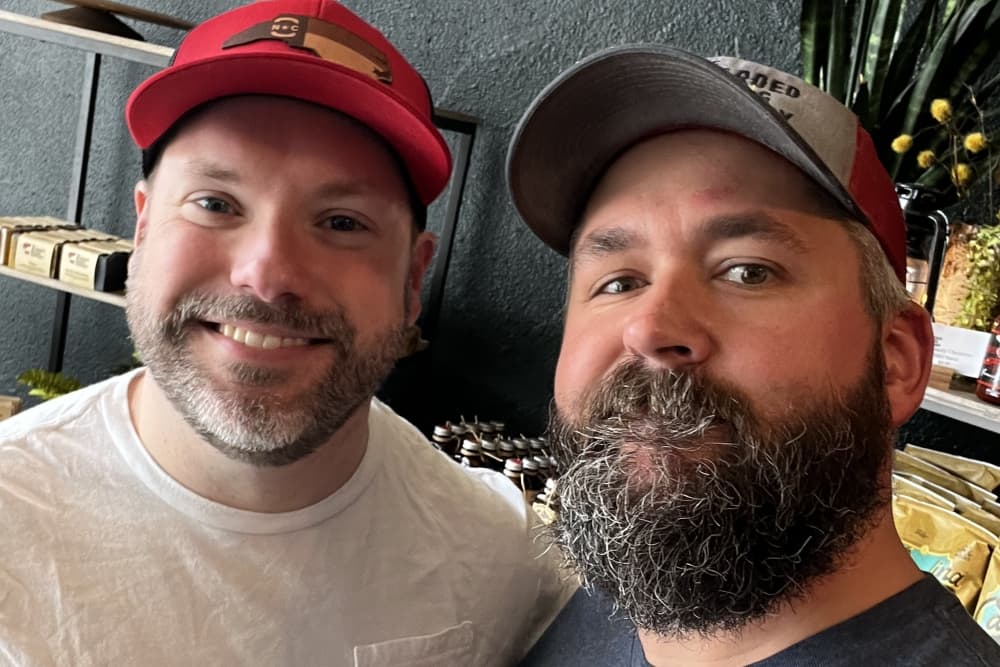 The two men smile for a selfie.