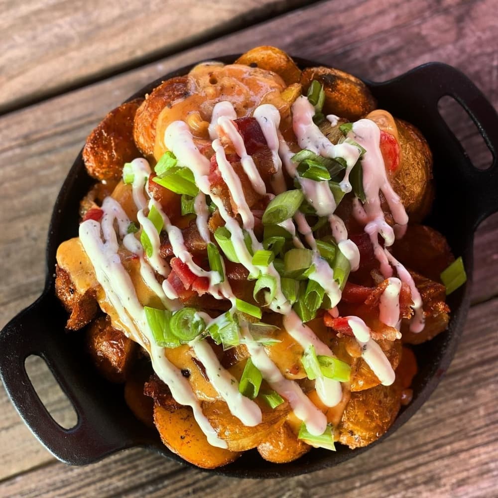 A black cast iron holds loaded potatoes.