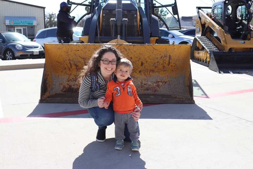 a mom and her son in front heavy equipment. 