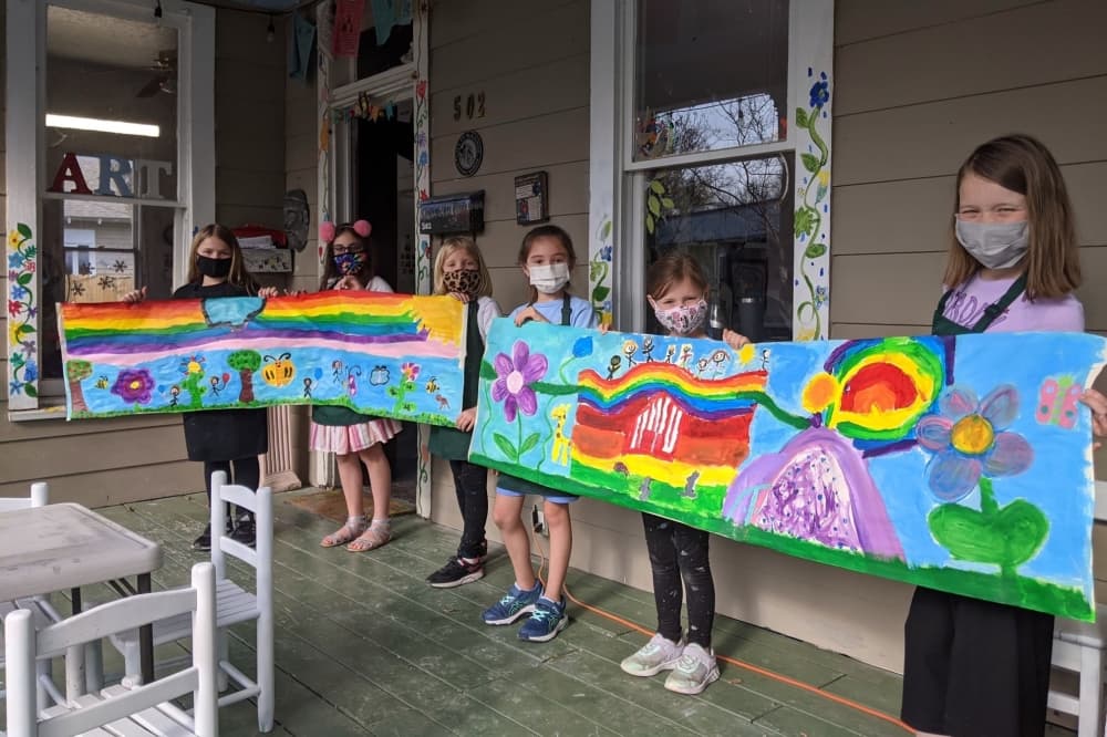 Children holding up an art piece