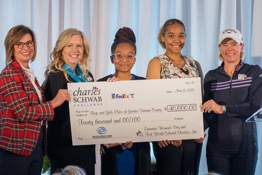 Five females holding a check sign.