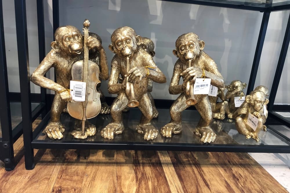 Golden hued statues of monkeys playing instruments. 