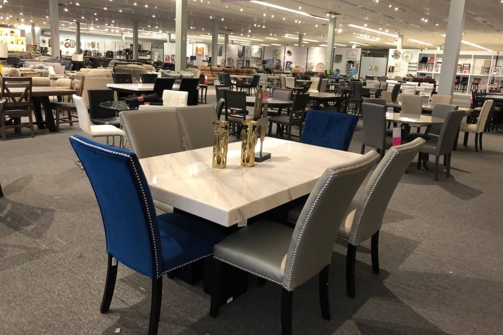Dining room table with chairs of varying colors. 