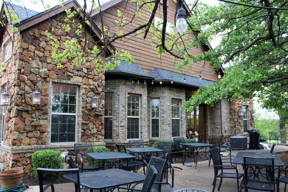 Outside patio by stone building. 