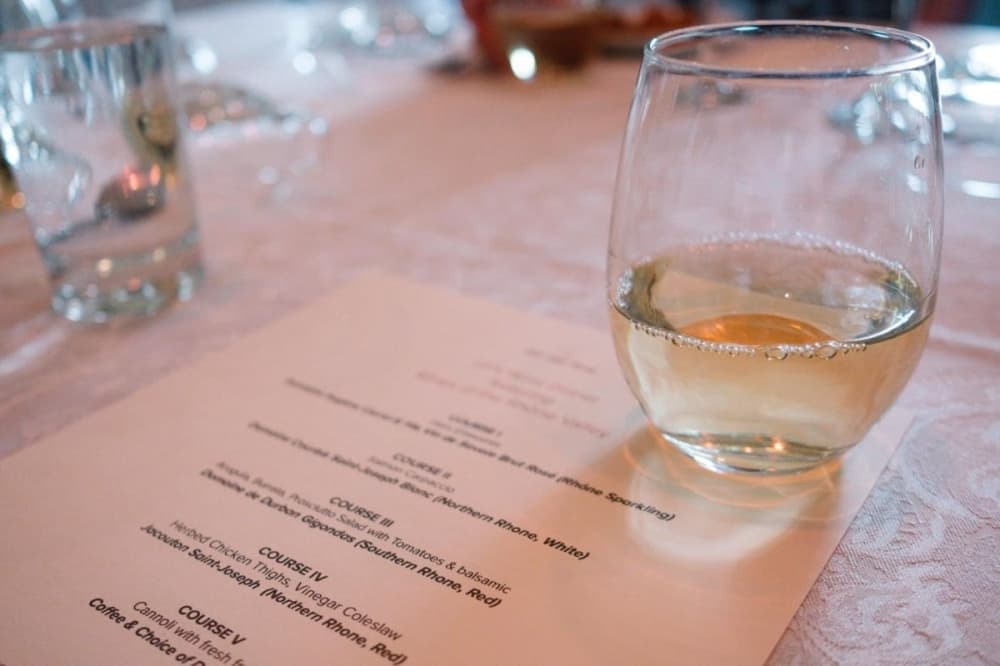 glass of wine and dinner menu at off the vine
