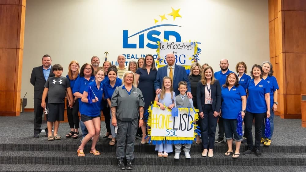 New principal posed with family and SSC staff