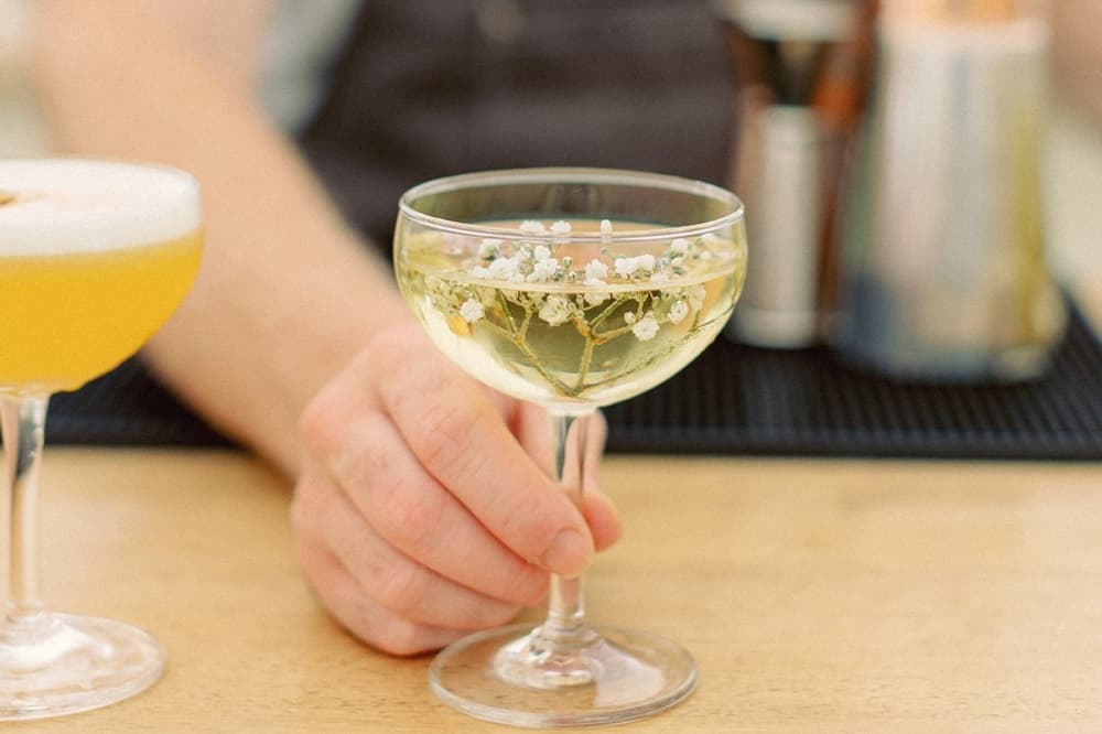 A transparent drink is shown with white flowers inside.