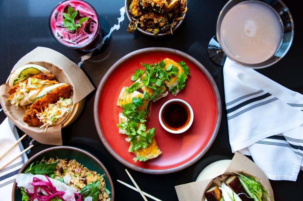 A variety of dishes are shown on a dark table.