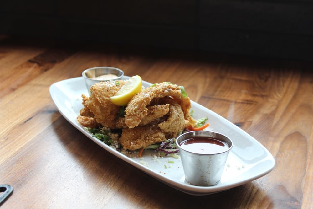 The catfish beignets ($14) are served with jalapeño aioli and tequila pineapple sauce. (Sarah Hernandez/Community Impact)