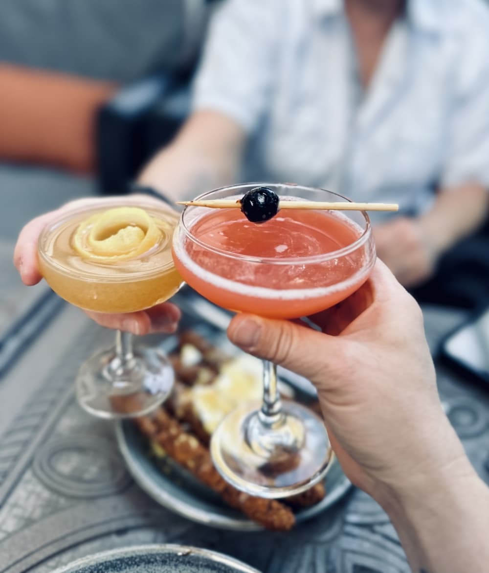 Two people toast cocktails