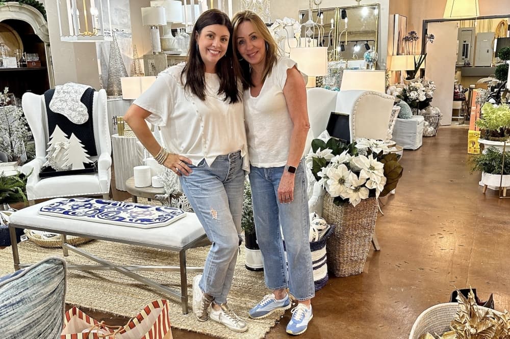 two woman smile for a photo in a home decor store