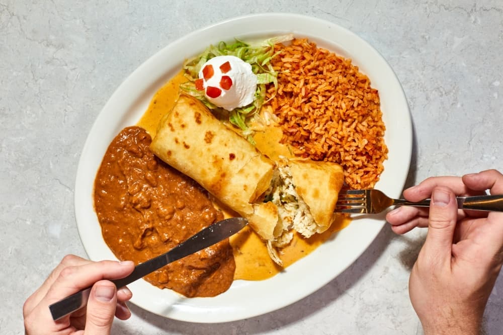 A white plate is shown with Mexican food.