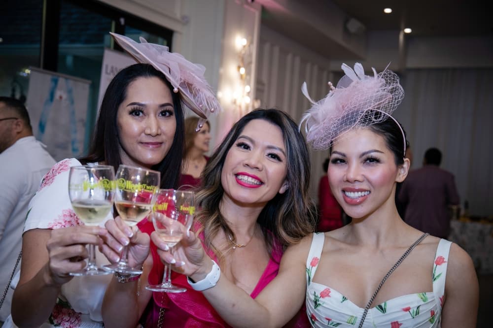 Three women present toasts with wine glasses