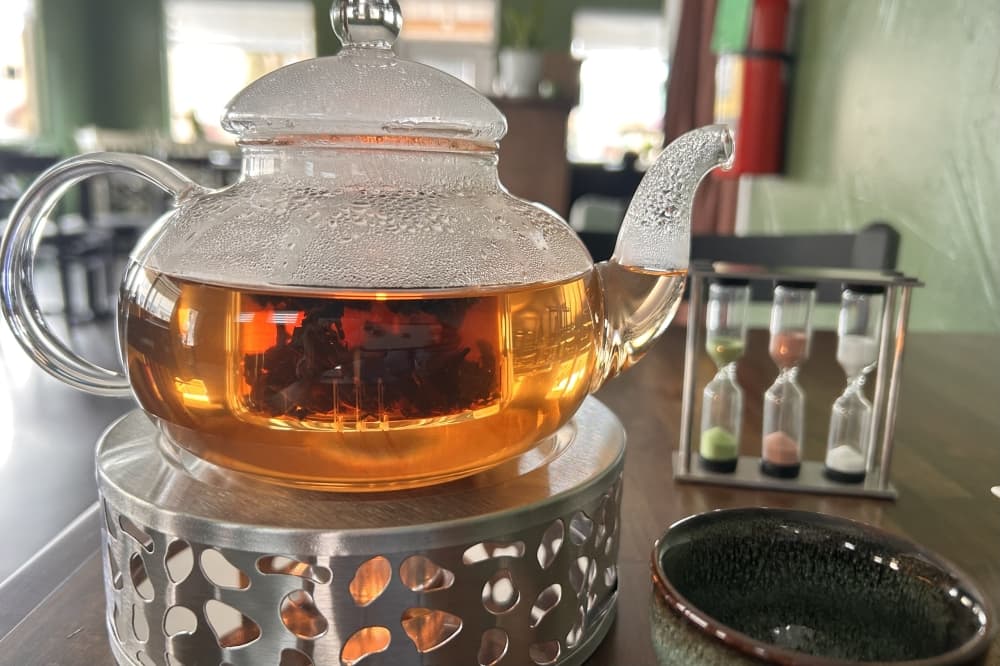 Tea is served in a glass kettle with a timer to guide how long one should steep the tea. (Shaheryar Khan/Community Impact)