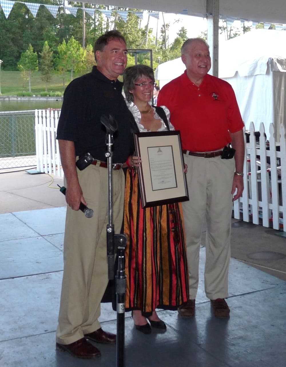 Three people pose with a document