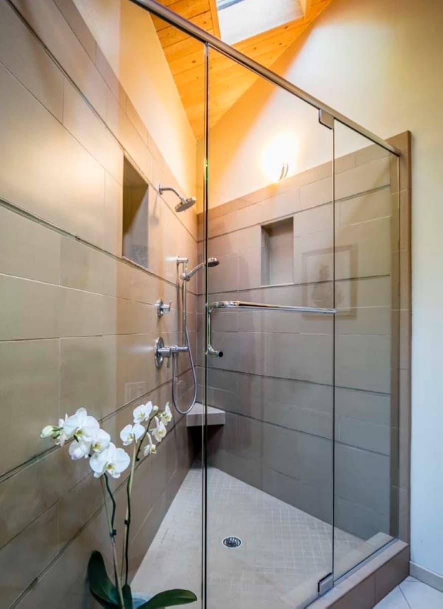 A corner shower is shown with bottom-to-top glass doors in the front.