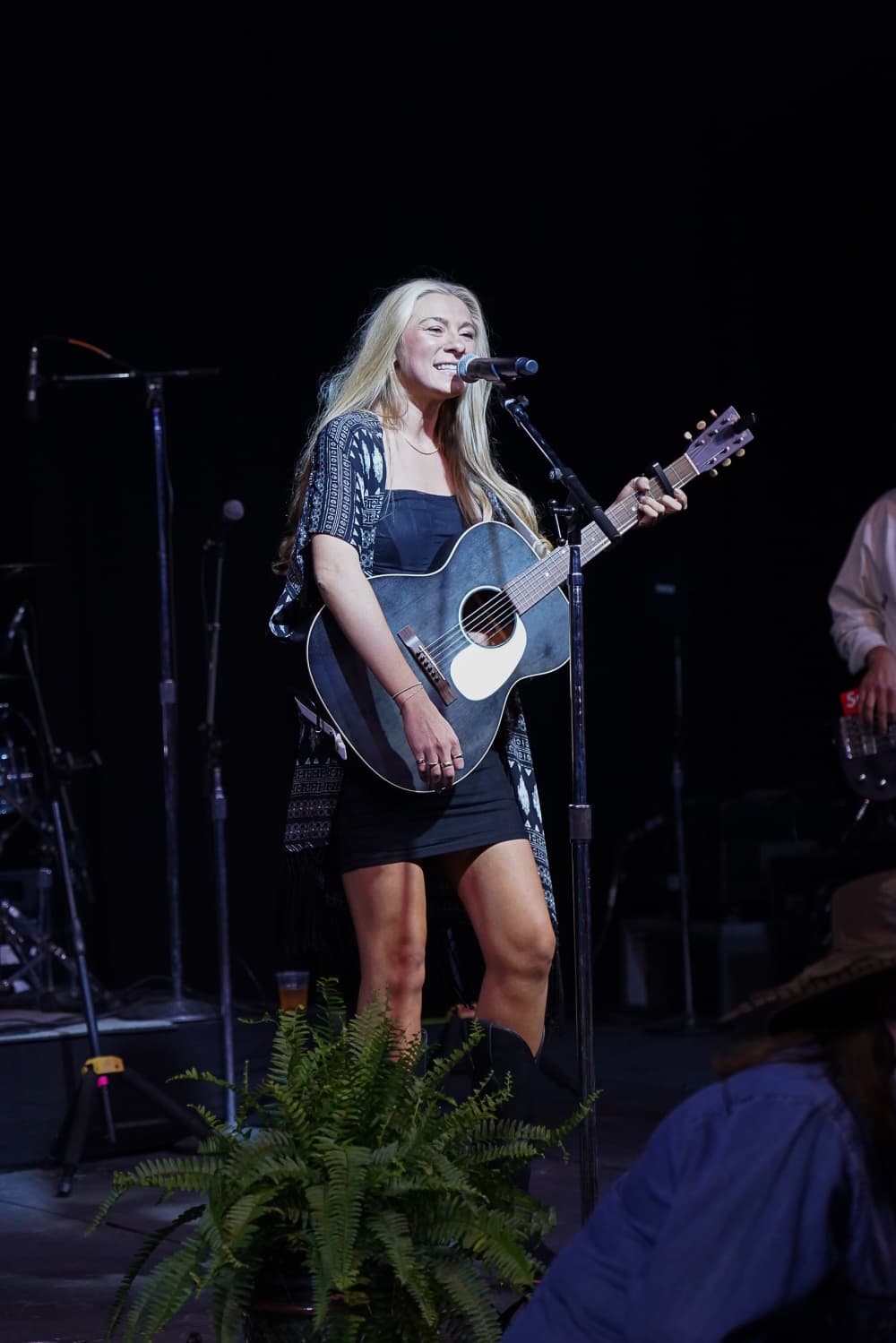 A woman performs with a guitar.