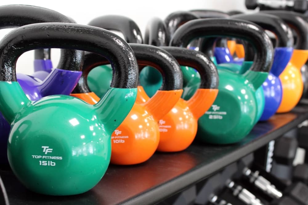 A variety of different weights and colors of kettlebells.